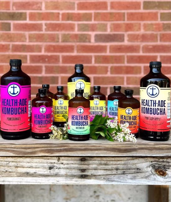 Bottles of Health-Ade kombucha arranged on a wooden display